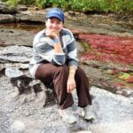 Visitante en caminata ecológica en Caño Cristales, destino de naturaleza en Colombia cerca de Bogotá.